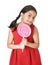 Sweet beautiful latin female child holding big pink spiral lollipop candy