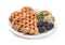 sweet Belgian waffles in the form of hearts with chocolate and berries on a white isolated background.