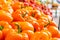 Sweet bell peppers orange bell peppers, being  sold in a farmer`s  market. Fresh, bright and shiny