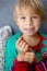 Sweet blond preschool child, boy, loosing his first milk tooth, smiling happily, holding the little tooth