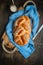 Sweet braided buns with sesame seeds on a blue kitchen towel.