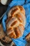 Sweet braided buns with sesame seeds on a blue kitchen towel.