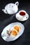 Sweet breakfast - cheese pancakes. Cottage cheese pancakes with sour cream on a white plate. Dark background.A cup of