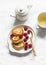 Sweet breakfast, snack, dessert - pancakes with sour cream and raspberries and green tea on a light background, top view