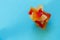 Sweet candied papaya yellow and red in the shape of a pyramid on top of each other on a blue background. Copy space