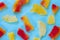 Sweet candied papayas in yellow and red on a blue background. Copy space