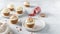 Sweet carrot cupcakes with whipped cream and dried fruits on white background. Bakery, confectionery banner, cookbook recipe, menu