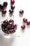 Sweet cherries in cherry glass bowl around white. close up