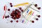 Sweet cherries in a round glass cup on a light background next to a notebook, multi-colored pens and a festive candle. Summer