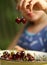 Sweet cherry merry in human hand with teenager girl on background