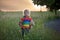 Sweet child, blond boy, playing in poppy field on a partly cloudy day, dramatic sky