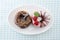 Sweet chocolate almond and strawberry cake doughnuts on a plate on tablecloth