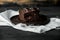 Sweet chocolate brownie with coffe cream on a dark, rustic, wooden table