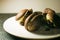 Sweet chocolate cakes - pastry with white cream on a round white plate.