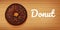 Sweet chocolate donut on wood background.