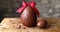 A sweet chocolate egg with red bow on a rustic wooden table, easter chocolates concept