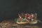 Sweet chocolate muffins decorated cherry in brown paper with ribbon on wooden bowl surrounded  pine branches