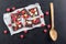 Sweet chocolate slices with fruits on white paper, sweet dessert with wooden spoon on black backgroud. image for patisserie