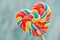 Sweet colored striped rainbow candy on a stick in the form of a heart. on a old vintage wooden background. The concept for Valenti