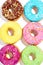 Sweet colorful glazed doughnuts on white background. Junk food top view, sugar treat