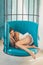 Sweet and comfort dream, morning. woman relax in cage chair at home. daytime sleep of cute tired girl in cage chair