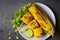 Sweet corn cooked on white plate, sweet corn food with salad vegetable lime coriander and lettuce, ripe corn cobs grilled