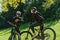 A sweet couple, equipped with bicycles and engrossed in coordinating their journey, checks their GPS mobile and watches