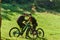 A sweet couple, equipped with bicycles and engrossed in coordinating their journey, checks their GPS mobile and watches