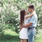 Sweet couple in love hugging over flowering garden