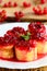 Sweet crepes rolls with redcurrant confiture on a white plate. Little stuffed crepes dessert recipe. Delicious Easter brunch idea