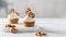 Sweet cupcakes with whipped cream and brezel on white marble tray. Bakery, confectionery banner, cookbook recipe, menu. Side view