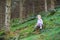 Sweet curly baby girl playing in pine wood forest