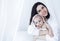 Sweet cute baby sits on the bed next to his mom and plays after bath