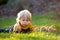 Sweet cute blond child, toddler boy, riding tricycle with little chicks in garden, playing with baby birds