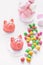 Sweet delicate macaroons of pink marzipan in the form of a mini-pig marshmallows, peanuts in sugar pastel colours on a