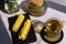 Sweet delicious eclairs and tea in a glass cup on the table with a vase of chamomile flowers