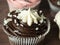 Sweet delicious and high-calorie chocolate cupcake on a wooden background. Food composition, sweetness, temptation, junk food