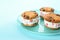 Sweet delicious ice cream cookie sandwiches on blue background, closeup