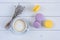 Sweet delicious violet and yellow macarons and cup of latte or americano and branch of fragrant lavender on white wooden