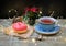 Sweet donut decorated for Christmas on a burlap with cup of tea