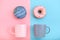 Sweet donuts pink and blue with a mug of coffee. Blue and pink background, game of colors, color conflict. Mock up for