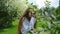 Sweet European girl is sniffing a blooming bird cherry, a slow motion. A woman with long lush hair enjoying nature in