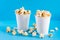 Sweet fast food. Caramel popcorn in paper cups on blue background