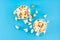 Sweet fast food. Caramel popcorn in paper cups on blue background. Top view