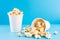 Sweet fast food. Caramel popcorn scattering from one paper cup on a blue background