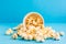 Sweet fast food. Caramel popcorn scattering from paper cup on blue background. Close-up