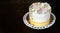 SWEET FLORAL BUTTERCREAM BIRTHDAY, ANNIVERSARY OR MOTHERS DAY CAKE AGAINST DARK WOODEN BACKGROUND