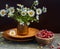 Sweet forest strawberries and a bouquet of daisies on a wooden background