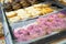 Sweet fresh donuts with icing lie on the shelf in the bakery