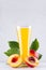 Sweet fresh yellow juice of peach and red nectarines with green leaves, juicy half cut on white wood table, vertical.
